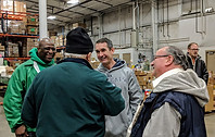 Eugene DePasquale speaking with food bank workers, highlighting his commitment to social justice and community support.